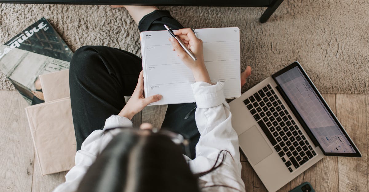 Yolks flat and breaking - Top view of anonymous woman in casual wear sitting on floor with laptop and smartphone and creating plan on notebook while resting during break in modern living room