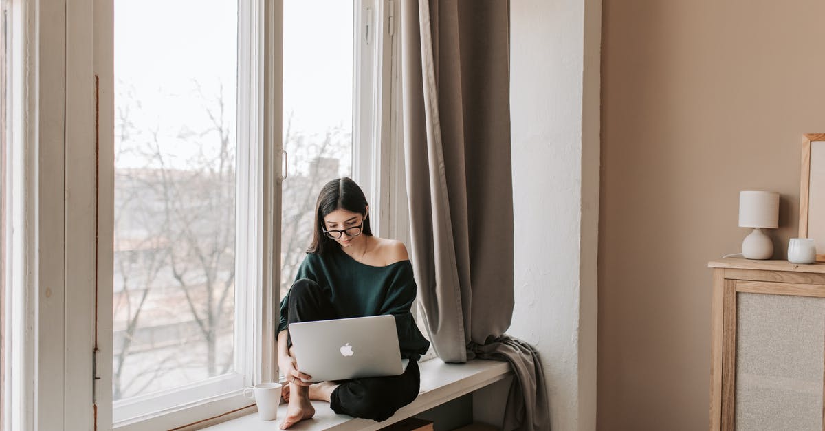 Yolks flat and breaking - Young female freelancer sitting with laptop on windowsill at home